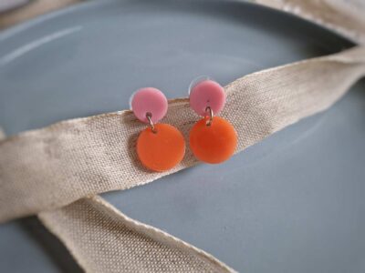 Die pfirsich-orangenen zierlichen Kreis-Ohrhänger punkten durch ihre flache, edle Form und die tollen harmonierenden Farben mit dem runden rosa Ohrstecker. 