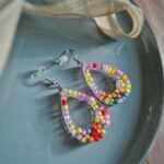 Diese Tropfenohrringe geben wunderbar bunte Boho-Ohrringe ab, indem sie mit bunten Liebesperlen mit Farbe um sich werfen - eine kreative Sache.