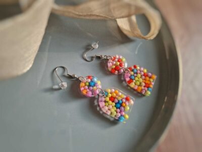Diese Bogenohrringe geben wunderbar bunte Boho-Ohrringe ab, indem sie mit bunten Liebesperlen mit Farbe um sich werfen - eine kreative Sache.