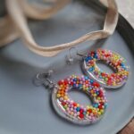Diese ovalen Ohrringe geben wunderbar bunte Boho-Ohrringe ab, indem sie mit bunten Liebesperlen mit Farbe um sich werfen - eine kreative Sache.