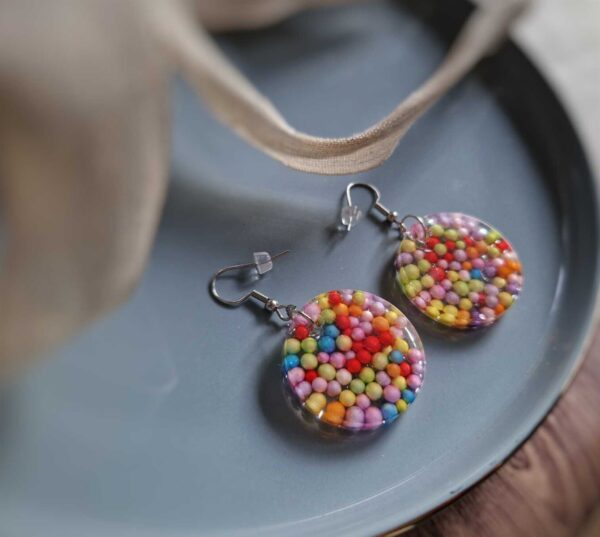 Diese ovalen Ohrringe geben wunderbar bunte Boho-Ohrringe ab, indem sie mit bunten Liebesperlen mit Farbe um sich werfen - eine kreative Sache.