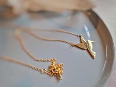 In glänzendem goldenen Edelstahl präsentiert sich dieser wunderschöne Kolibri-Kettenanhänger.
