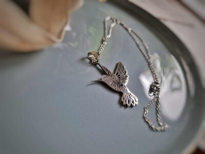 In glänzendem silbernen Edelstahl präsentiert sich dieser wunderschöne Kolibri-Kettenanhänger.