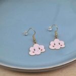 Diese zierlichen Ohrhänger zeigen sich von ihrer nostalgischen Retroseite und präsentieren eine niedliche rosa Wolke