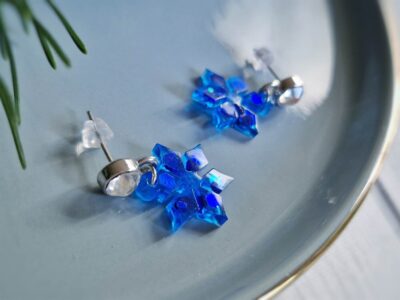 Die zierlichen Sternen-Ohrhänger zelebrieren das Wintergefühl auf eine besondere Weise. Sie glitzern mit den silber funkelnden Kristall-Ohrstecker elegant dunkelblau um die Wette.