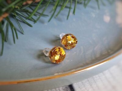 Diese handgefertigten rund-flachen Ohrstecker setzen auf eine dezent-elegante Weise Akzente und überzeugen durch ein funkelndes Gold von kleinen glitzernden Sternen.