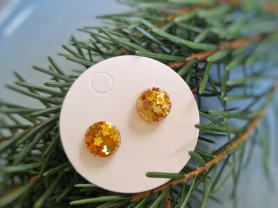 Diese handgefertigten rund-flachen Ohrstecker setzen auf eine dezent-elegante Weise Akzente und überzeugen durch ein funkelndes Gold von kleinen glitzernden Sternen.