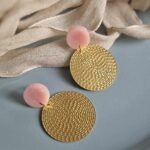 Unter den runden elegant glitzernden rosa Ohrsteckern hängen hauchzarte goldene Kreisohrhänger in Rattan-Optik aus Metall und geben diesen romantischen eleganten Ohrringen das romantische Etwas.