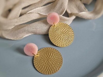 Unter den runden elegant glitzernden rosa Ohrsteckern hängen hauchzarte goldene Kreisohrhänger in Rattan-Optik aus Metall und geben diesen romantischen eleganten Ohrringen das romantische Etwas.