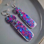 In den transparenten organic-Anhängern wurden glitzernde pink-blaue Pailletten gegossen, die je nach Lichteinfall strahlend leuchten