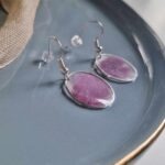 In eine hauchzarte silberne Kreislünette wurde mit transparenten Resin violettes Puder gegossen, um diese elegante Farbkomposition zu kreieren.