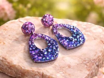 In den transparenten Boho-Anh&auml;ngern wurden feine glitzernde Pailletten in geheimnisvollen violett und lila T&ouml;nen gegossen, die je nach Lichteinfall changierend flieder leuchten, Akzente setzen und diese Statementohrringe zu&nbsp; individuellen Begleitern machen.