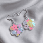 In den transparenten Blumen-Anhängern wurden glitzernde Blumen- und Muschel-Pailletten in sommerlichen Pastelltönen gegossen, die je nach Lichteinfall strahlend türkis-changierend leuchten, Akzente setzen und diese Statementohrringe zu  individuellen Begleitern machen. 