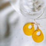 Im Hippie-Stil präsentieren sich diese großzügigen Tropfenohrringe aus Resin, die mit der fröhlich stimmenden Farbe Gelb und Glimmer aufwarten.