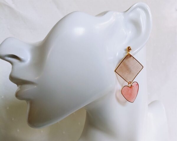 Elegante Pastelltöne in Braun und Altrosa in Verbindung mit der Quadrat- und Herzform verleihen diesem Ohrringdesign eine fröhliche Note.