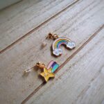 Diese zierlichen Ohrhänger zeigen sich von ihrer nostalgischen Retroseite und präsentieren einen Regenbogen mit Wolke und eine Sternschnuppen á la Regina Regenbogen in bunten Tönen.