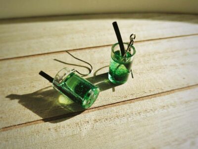 Diese zierlichen Ohrhänger zeigen sich von ihrer spritzigen Seite und präsentieren einen bgrünen Cocktail á la "grüne Witwe" im Glas