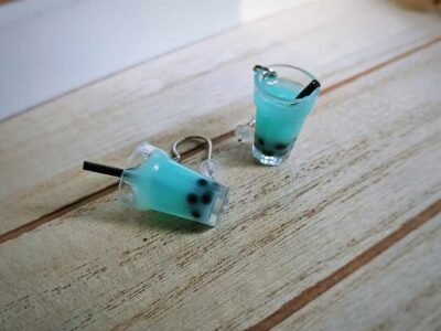 Diese zierlichen Ohrhänger zeigen sich von ihrer spritzigen Seite und präsentieren einen Bubble Tea mit türkis-blauem Inhalt im Glas.