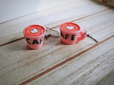 Diese niedlichen Ohrhänger zeigen sich von ihrer Morgenseite und präsentieren eine rosafarbene Kaffeetasse mit Kaffee im Becher