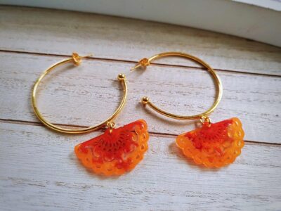 An wunderschön goldglänzenden Creolen hängen orange-ocker farbige orientalische Ornamentfächer und schaukeln bei deinen Bewegungen elegant mit.